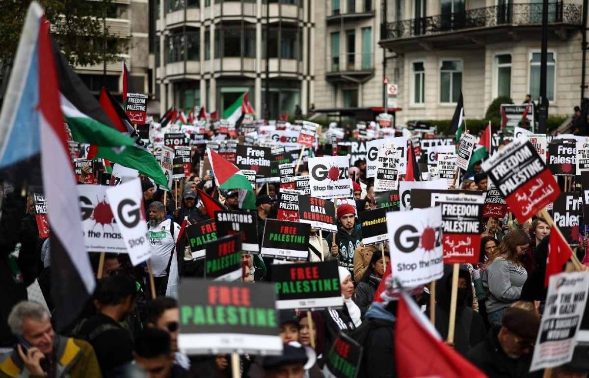 As pessoas reúnem-se com cartazes para participar numa Marcha pela Palestina em Londres, no dia 21 de outubro de 2023, para 