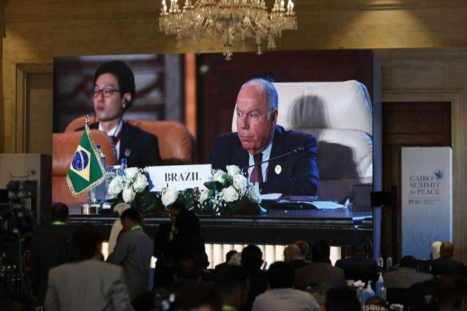 Journalists watch a large screen showing the Brazilian Foreign Minister Mauro Vieira addressing the International Peace Summit hosted by the Egyptian president in the New Administrative Capital (NAC), about 45 kilometres east of Cairo, on October 21, 2023, amid the ongoing battles between Israel and the Palestinian group Hamas. Thousands of people, both Israeli and Palestinians have died since October 7, 2023, after Palestinian Hamas militants based in the Gaza Strip, entered southern Israel in a surprise attack leading Israel to declare war on Hamas in Gaza on October 8 - (crédito: Khaled Desouki/AFP) Journalists watch a large screen showing the Brazilian Foreign Minister Mauro Vieira addressing the International Peace Summit hosted by the Egyptian president in the New Administrative Capital (NAC), about 45 kilometres east of Cairo, on October 21, 2023, amid the ongoing battles between Israel and the Palestinian group Hamas. Thousands of people, both Israeli and Palestinians have died since October 7, 2023, after Palestinian Hamas militants based in the Gaza Strip, entered southern Israel in a surprise attack leading Israel to declare war on Hamas in Gaza on October 8 - (crédito: Khaled Desouki/AFP)