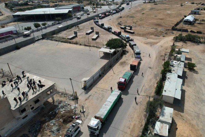 Nesta vista aérea, um comboio de caminhões que transportam ajuda humanitária entra na Faixa de Gaza vindo do Egito através da passagem de fronteira de Rafah em 21 de outubro de 2023       -  (crédito: MOHAMMED ABED / AFP)