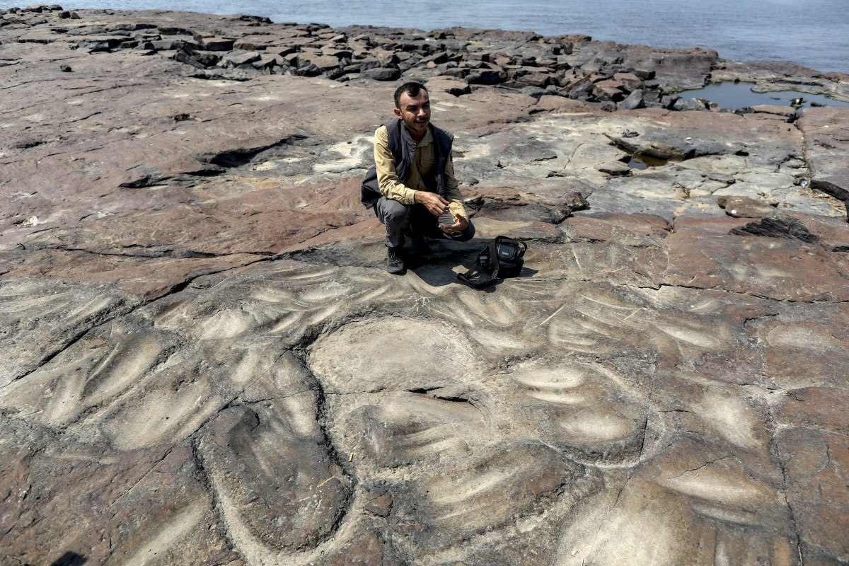O arqueólogo Jaime Oliveira, do Instituto do Patrimônio Histórico e Artístico Nacional (Iphan), mostra antigas gravuras rupestres que reapareceram na região do Sítio Arqueológico das Lajes 