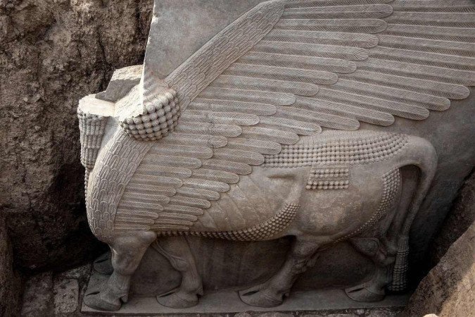 Esta foto tirada em 24 de outubro de 2023 mostra uma escultura de alabastro assíria recentemente desenterrada de Lamassu (touro alado com cabeça humana), descoberta com as asas inteiras intactas pela missão arqueológica francesa no sítio arqueológico de Khorsabad -  (crédito: Zaid AL-OBEIDI / AFP)