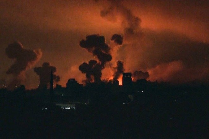 Esta imagem obtida de uma filmagem da TV AFP mostra fogo e fumaça subindo acima da cidade de Gaza durante um ataque israelense em 27 de outubro de 2023, enquanto as batalhas entre Israel e o movimento palestino Hamas continuam. - (crédito: AFP) Esta imagem obtida de uma filmagem da TV AFP mostra fogo e fumaça subindo acima da cidade de Gaza durante um ataque israelense em 27 de outubro de 2023, enquanto as batalhas entre Israel e o movimento palestino Hamas continuam. - (crédito: AFP)