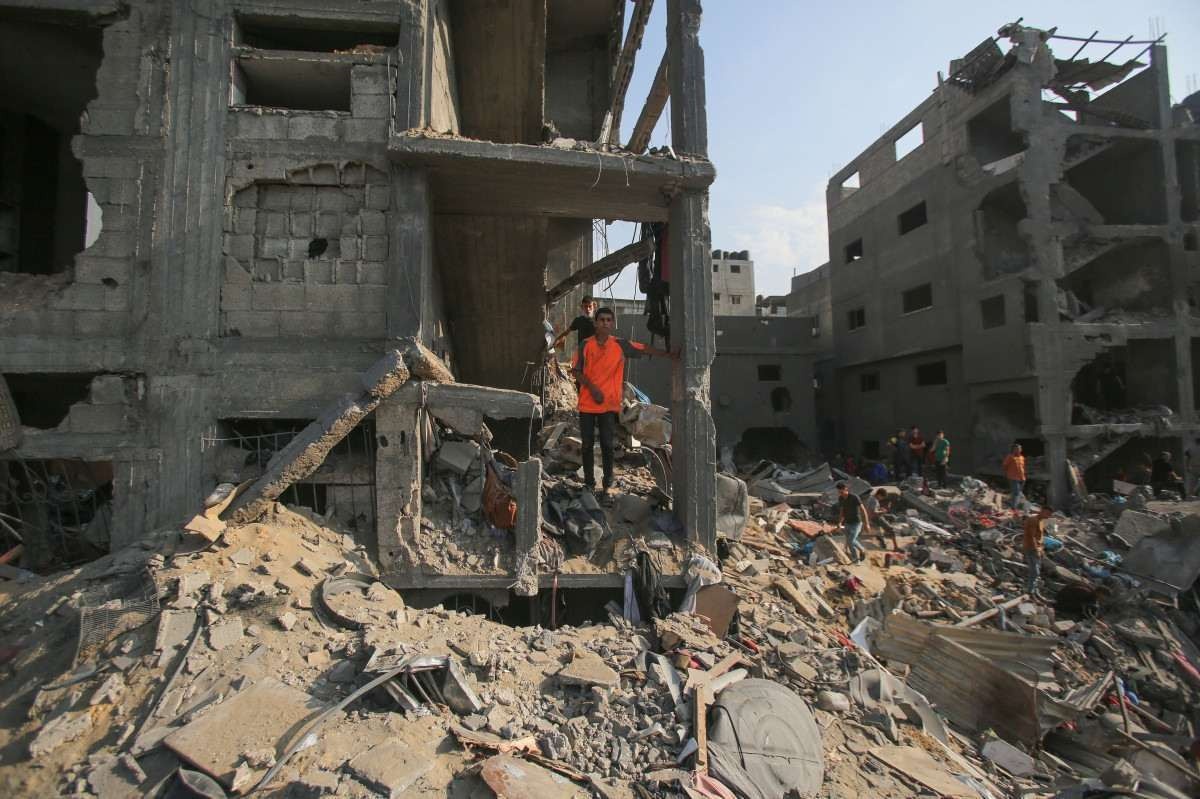 Os palestinos verificam a destruição após um ataque israelense no campo para refugiados de Jabaliya na Faixa de Gaza