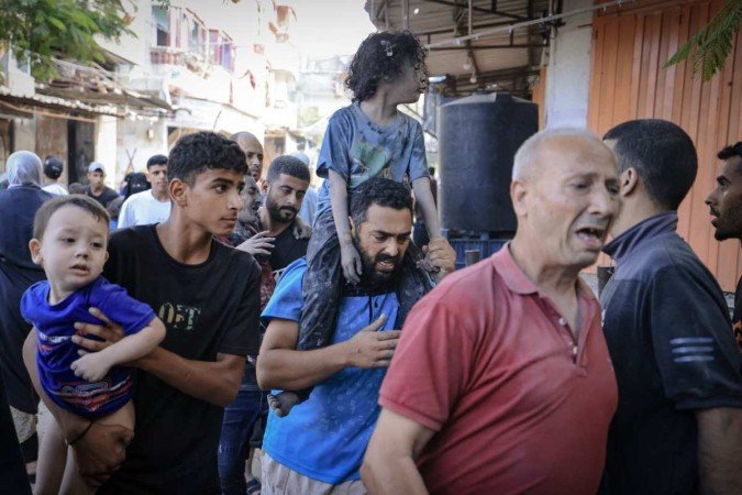Crianças são levadas para um abrigo em Bureij, no centro da Faixa de Gaza, em meio a um confronto entre forças israelenses e o Hamas - (crédito: Mahmud Hams/AFP) Crianças são levadas para um abrigo em Bureij, no centro da Faixa de Gaza, em meio a um confronto entre forças israelenses e o Hamas - (crédito: Mahmud Hams/AFP)
