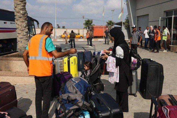 Civis que deixam Gaza esperam para embarcar em um Ã?Åœnibus enquanto palestinos e estrangeiros com dupla nacionalidade se preparam para cruzar o ponto fronteiriÃ?§o de Rafah com o Egito - (crédito: MOHAMMED ABED / AFP) Civis que deixam Gaza esperam para embarcar em um Ã?Åœnibus enquanto palestinos e estrangeiros com dupla nacionalidade se preparam para cruzar o ponto fronteiriÃ?§o de Rafah com o Egito - (crédito: MOHAMMED ABED / AFP)