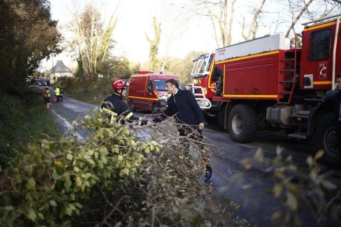 Emmanuel Macron, aperta a mão de um bombeiro durante visita a região atingida pela tempestade Ciaran - (crédito: Yoan VALAT / POOL / AFP) Emmanuel Macron, aperta a mão de um bombeiro durante visita a região atingida pela tempestade Ciaran - (crédito: Yoan VALAT / POOL / AFP)