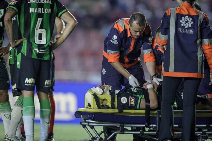 Enfermeiros imobilizam Rodriguinho. Jogador do América teve um choque de cabeça com Rubens. Ambos foram para o hospital - (crédito: Pedro Souza/Atlético) Enfermeiros imobilizam Rodriguinho. Jogador do América teve um choque de cabeça com Rubens. Ambos foram para o hospital - (crédito: Pedro Souza/Atlético)