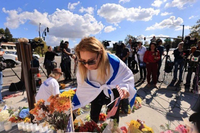 Uma mulher coloca flores em 7 de novembro de 2023 no local onde Paul Kessler, um judeu que morreu após uma altercação durante duelos de manifestações pró-palestinianas e pró-israelenses no dia anterior. -  (crédito: DAVID SWANSON / AFP)