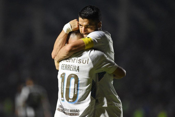 Suárez abraça Ferreira na comemoração de um dos seus três gols na vitória sobre o Botafogo no Campeonato Brasileiro
- (crédito: Jogada1Alexandre Durão/Grêmio FBPA0) Suárez abraça Ferreira na comemoração de um dos seus três gols na vitória sobre o Botafogo no Campeonato Brasileiro
- (crédito: Jogada1Alexandre Durão/Grêmio FBPA0)
