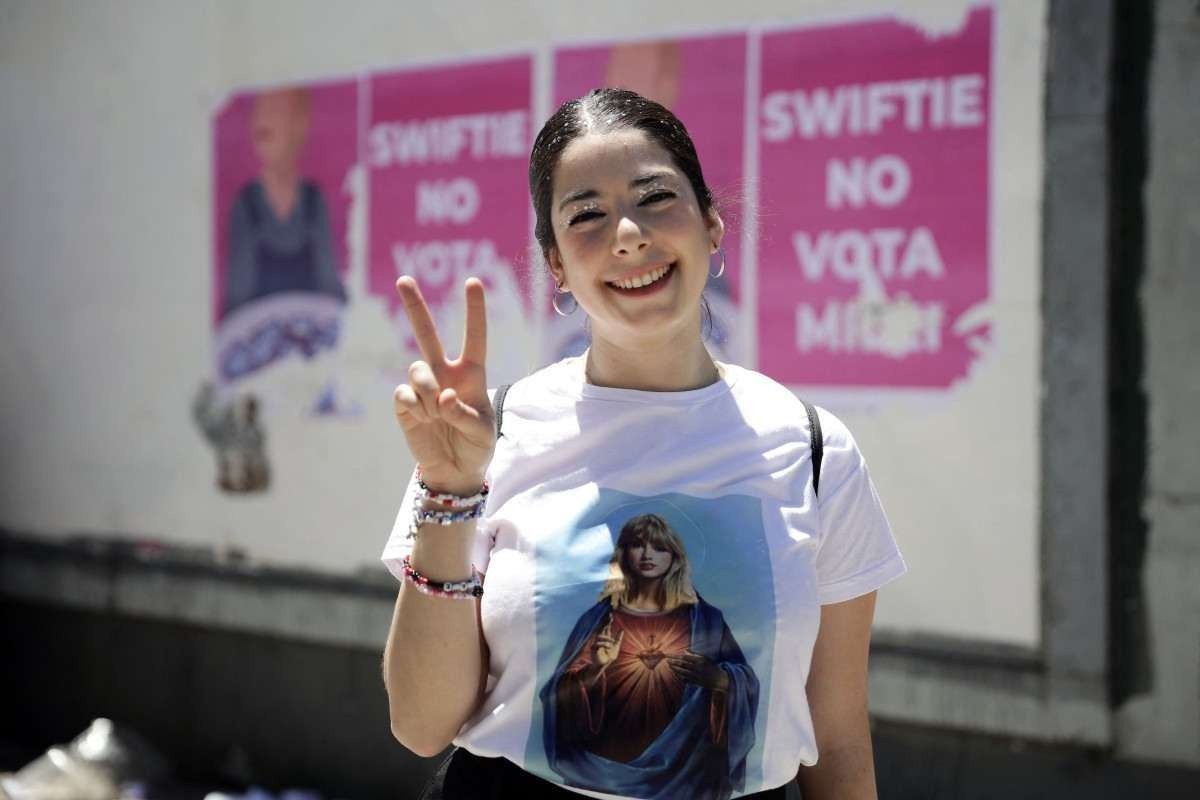 Uma fã da cantora norte-americana Taylor Swift posa para uma foto enquanto faz fila do lado de fora do estádio Mas Monumental antes do show de Swift 