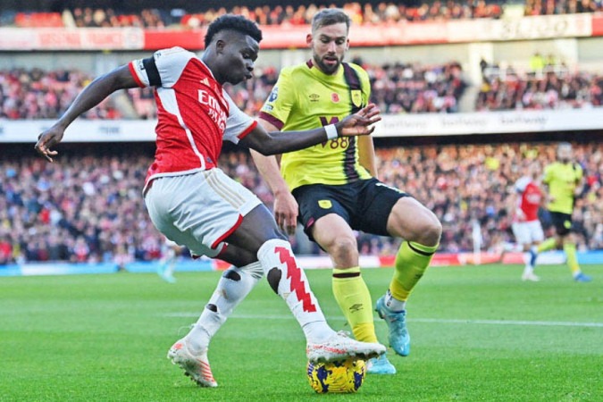  Arsenal's English midfielder #07 Bukayo Saka (L) vies with Burnley's English defender #03 Charlie Taylor (R) during the English Premier League football match between Arsenal and Burnley at the Emirates Stadium in London on November 11, 2023. (Photo by Glyn KIRK / AFP) / RESTRICTED TO EDITORIAL USE. No use with unauthorized audio, video, data, fixture lists, club/league logos or 'live' services. Online in-match use limited to 120 images. An additional 40 images may be used in extra time. No video emulation. Social media in-match use limited to 120 images. An additional 40 images may be used in extra time. No use in betting publications, games or single club/league/player publications. /  (Photo by GLYN KIRK/AFP via Getty Images)
     -  (crédito:  AFP via Getty Images)