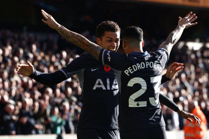  Tottenham Hotspur's Welsh striker #22 Brennan Johnson (L) celebrates with Tottenham Hotspur's Spanish defender #23 Pedro Porro (R) after scoring the opening goal of the English Premier League football match between Wolverhampton Wanderers and Tottenham Hotspur at the Molineux stadium in Wolverhampton, central England on November 11, 2023. (Photo by Darren Staples / AFP) / RESTRICTED TO EDITORIAL USE. No use with unauthorized audio, video, data, fixture lists, club/league logos or 'live' services. Online in-match use limited to 120 images. An additional 40 images may be used in extra time. No video emulation. Social media in-match use limited to 120 images. An additional 40 images may be used in extra time. No use in betting publications, games or single club/league/player publications. /  (Photo by DARREN STAPLES/AFP via Getty Images)
       -  (crédito:  AFP via Getty Images)