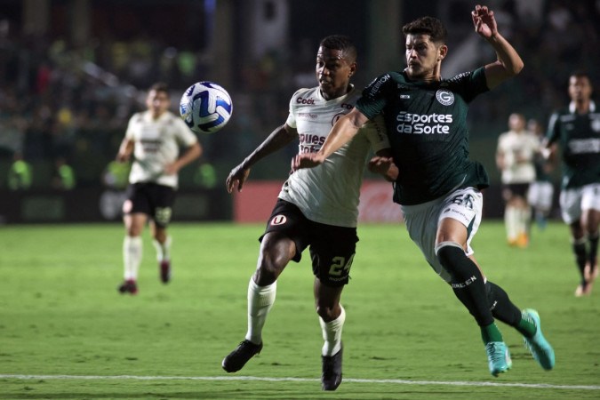  Universitario's forward Andy Polo (L) and Goias' defender Hugo vie for the ball during the Copa Sudamericana group stage second leg football match between Brazil's Goias and Peru's Universitario, at the Haile Pinheiro stadium in Goiania, Brazil, on May 23, 2023. (Photo by ANDRE COSTA / AFP) (Photo by ANDRE COSTA/AFP via Getty Images)
       -  (crédito:  AFP via Getty Images)