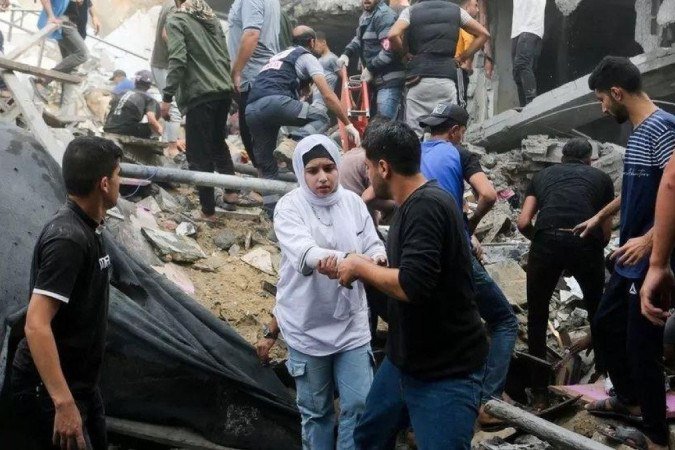 Palestinos procuram vítimas em local de ataque israelense, no sul da Faixa de Gaza - (crédito: Reuters) Palestinos procuram vítimas em local de ataque israelense, no sul da Faixa de Gaza - (crédito: Reuters)