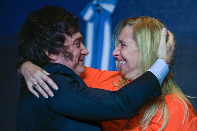 Argentine presidential candidate for the La Libertad Avanza alliance Javier Milei (L) celebrates with his sister Karina Milei after winning the presidential election runoff at his party headquarters in Buenos Aires on November 19, 2023. Libertarian outsider Javier Milei pulled off a massive upset Sunday with a resounding win in Argentina's presidential election, a stinging rebuke of the traditional parties that have overseen decades of economic decline. (Photo by LUIS ROBAYO / AFP)
- (crédito: LUIS ROBAYO/AFP) Argentine presidential candidate for the La Libertad Avanza alliance Javier Milei (L) celebrates with his sister Karina Milei after winning the presidential election runoff at his party headquarters in Buenos Aires on November 19, 2023. Libertarian outsider Javier Milei pulled off a massive upset Sunday with a resounding win in Argentina's presidential election, a stinging rebuke of the traditional parties that have overseen decades of economic decline. (Photo by LUIS ROBAYO / AFP)
- (crédito: LUIS ROBAYO/AFP)