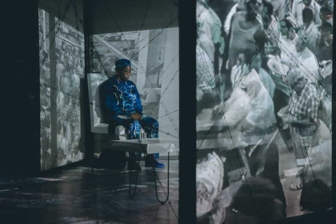 Na sala de embarque de um aeroporto, os dois personagens conversam sobre suas origens - (crédito: Caio Lírio) Na sala de embarque de um aeroporto, os dois personagens conversam sobre suas origens - (crédito: Caio Lírio)