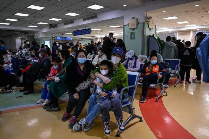 Crianças e adultos esperam em uma área de atendimento ambulatorial num hospital de Pequim por causa de problemas nas vias aéreas - (crédito: AFP) Crianças e adultos esperam em uma área de atendimento ambulatorial num hospital de Pequim por causa de problemas nas vias aéreas - (crédito: AFP)