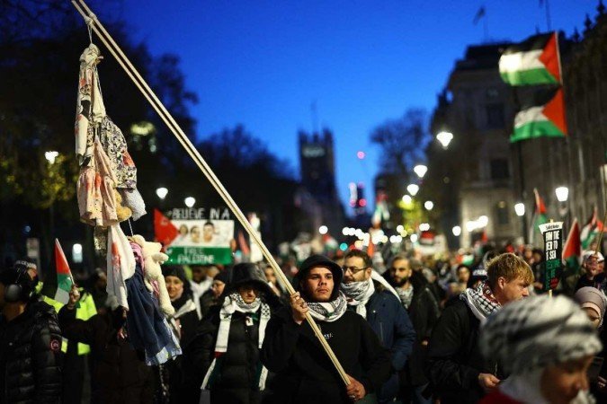 Os manifestantes agitam bandeiras e faixas enquanto participam numa 