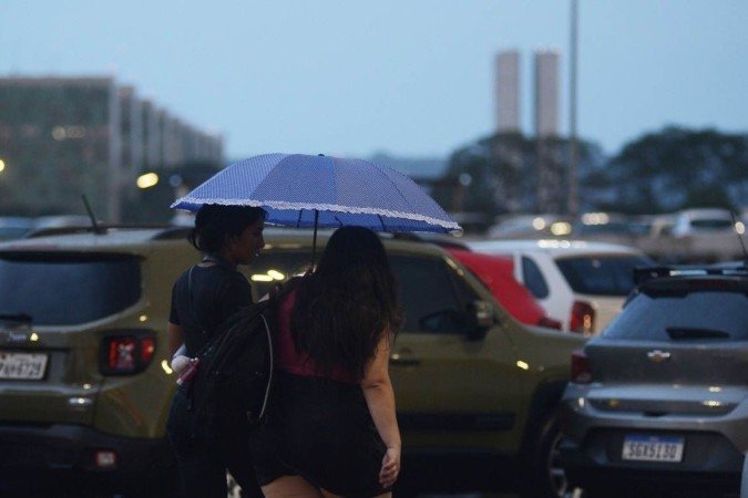 Mulheres se protegem da chuva no centro de Brasília. - (crédito: Ed Alves/CB/D.A Press) Mulheres se protegem da chuva no centro de Brasília. - (crédito: Ed Alves/CB/D.A Press)