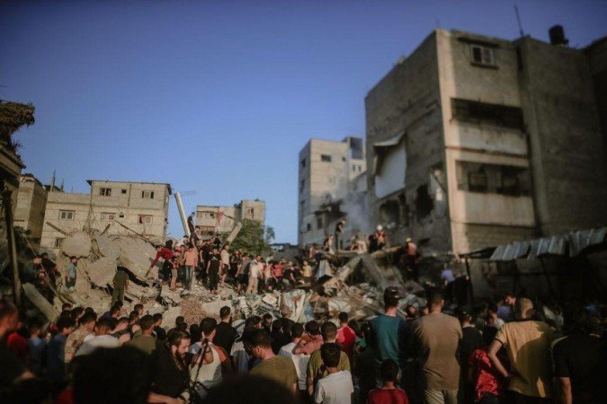 Civis e equipes de resgate palestinas vasculham os escombros dos edifícios destruídos durante os ataques aéreos israelenses no sul da Faixa de Gaza, especialmente em Khan Yunis, Gaza, em 4 de novembro de 2023 - (crédito: Getty Images) Civis e equipes de resgate palestinas vasculham os escombros dos edifícios destruídos durante os ataques aéreos israelenses no sul da Faixa de Gaza, especialmente em Khan Yunis, Gaza, em 4 de novembro de 2023 - (crédito: Getty Images)