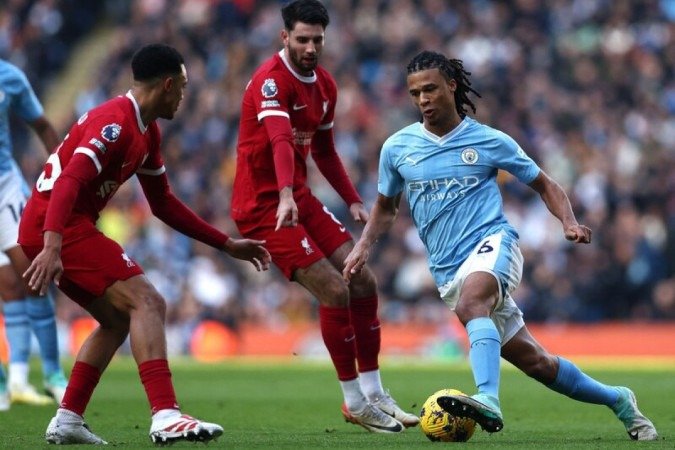 Aké (de azul) tenta levar o City ao ataque no duelo com o Liverpool. No fim, 1 a 1  -  (crédito: Foto: Darren Staples/AFP via Getty Images)