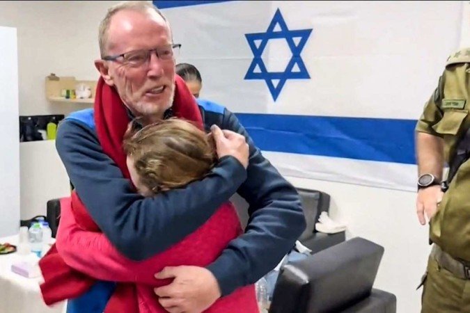 Imagem divulgada pelo exército israelense mostra Emily Hand, ex-refém israelense irlandesa de 9 anos, abraçando o pai em um hospital em Israel após ser libertada pelo Hamas. -  (crédito: Israel Army / AFP))