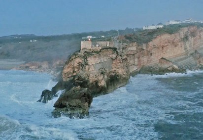 A Praia de Nazaré, em Portugal, é uma das mais perigosas e traiçoeiras do planeta. Ela fica ao norte de Lisboa e ganhou fama pelo gigantismo e pela ferocidade de suas ondas.   -  (crédito: Captura de vídeo do site www.redbull.com/br-pt)