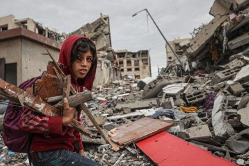 Criança recolhe lenha nos prédios destruídos em Gaza  -  (crédito: Getty Images)