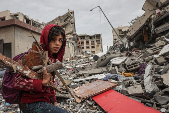 Criança recolhe lenha nos prédios destruídos em Gaza - (crédito: Getty Images) Criança recolhe lenha nos prédios destruídos em Gaza - (crédito: Getty Images)