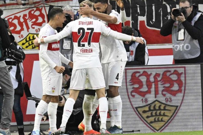 Stuttgart's German midfielder #27 Chris Fuehrich celebrates with teammates after he scored the opening goal during the German first division Bundesliga football match between VfB Stuttgart and Bayer Leverkusen in Stuttgart, southern Germany, on December 10, 2023. -  (crédito: Thomas Kienzle/AFP)