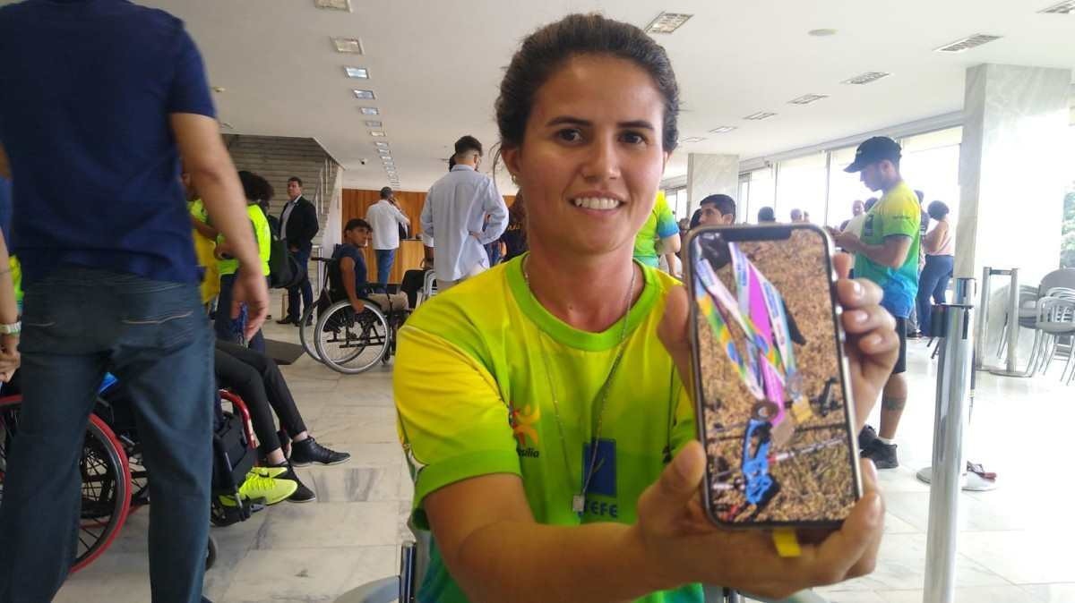 Paratleta do Recanto das Emas, Helena Moraes, 32, mostra foto de medalhas no celular
