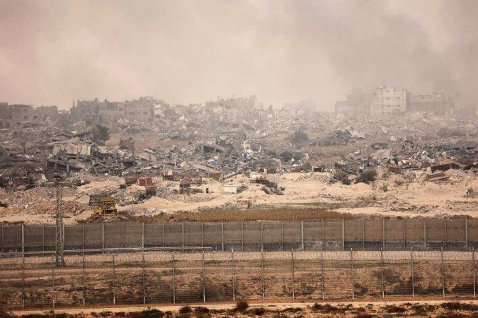 Prédios da Faixa de Gaza arrasados pelos bombardeios, em foto tirada do sul de Israel - (crédito: Gil Cohen-Magen/AFP) Prédios da Faixa de Gaza arrasados pelos bombardeios, em foto tirada do sul de Israel - (crédito: Gil Cohen-Magen/AFP)