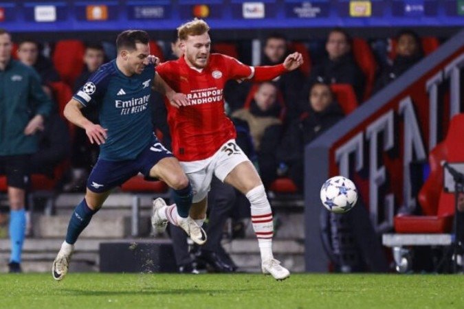 Jogadores de PSV e Arsenal em disputa de bola na última rodada da fase de grupos da Champions - Foto: Kenzo Tribouillard/AFP via Getty Images - (crédito: Foto: Kenzo Tribouillard/AFP via Getty Images) Jogadores de PSV e Arsenal em disputa de bola na última rodada da fase de grupos da Champions - Foto: Kenzo Tribouillard/AFP via Getty Images - (crédito: Foto: Kenzo Tribouillard/AFP via Getty Images)