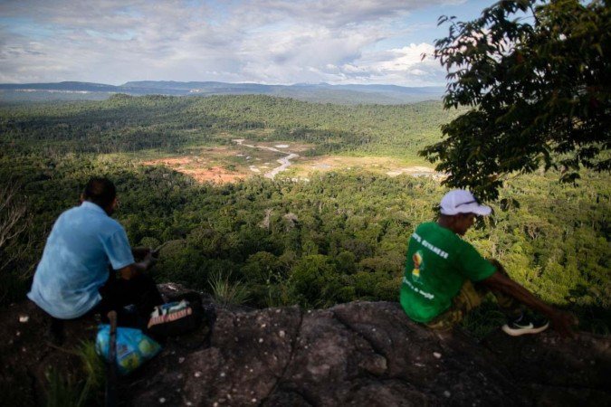 Thomas Devroy e Lindon Peter, ambos moradores da aldeia Arau, olham parte da região de Essequibo enquanto caminham pela selva -  (crédito: ROBERTO CISNEROS/ AFP)