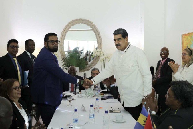 Os presidentes Irfaan Ali (E), da Guiana, e Nicolás Maduro (D), da Venezuela, selam o primeiro encontro com um aperto de mãos, em São Vicente e Granadinas  -  (crédito: Marcelo García/Presidência da Venezuela/AFP)
