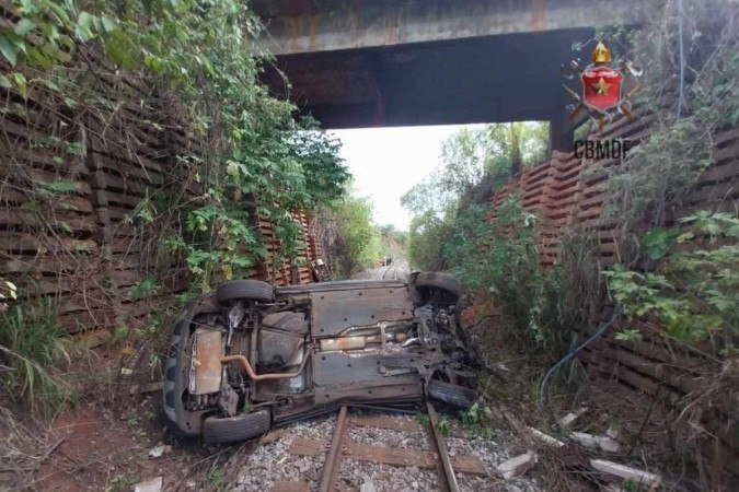 Carro cai de ponte e fica sobre trilhos do trem na DF 001, próximo à Vila da Marinha. - (crédito: Divulgação/CBMDF) Carro cai de ponte e fica sobre trilhos do trem na DF 001, próximo à Vila da Marinha. - (crédito: Divulgação/CBMDF)