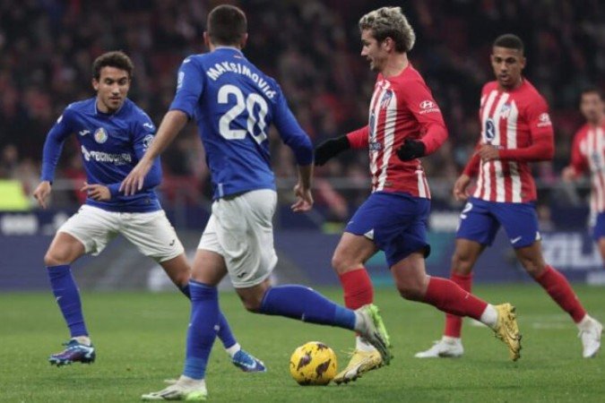 Antoine Griezmann em disputa de bola com jogadores do Getafe - Foto: Thomas Coex/AFP via Getty Images -  (crédito: Foto: Thomas Coex/AFP via Getty Images)