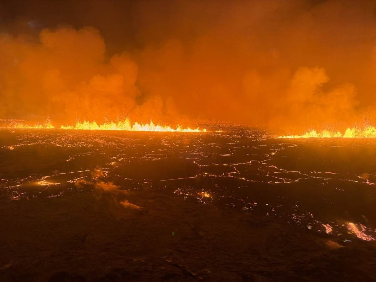Fumaça ondulante e lava fluindo tornando o céu laranja são vistos nesta imagem de folheto do Departamento de Proteção Civil e Gerenciamento de Emergências da Islândia      