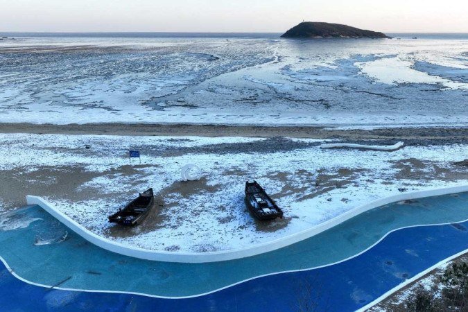 As temperaturas nas cidades do norte da China atingiram mínimos recordes em 20 de dezembro, quando as autoridades emitiram um alerta para frio extremo em partes do país - (crédito: STR / AFP) As temperaturas nas cidades do norte da China atingiram mínimos recordes em 20 de dezembro, quando as autoridades emitiram um alerta para frio extremo em partes do país - (crédito: STR / AFP)