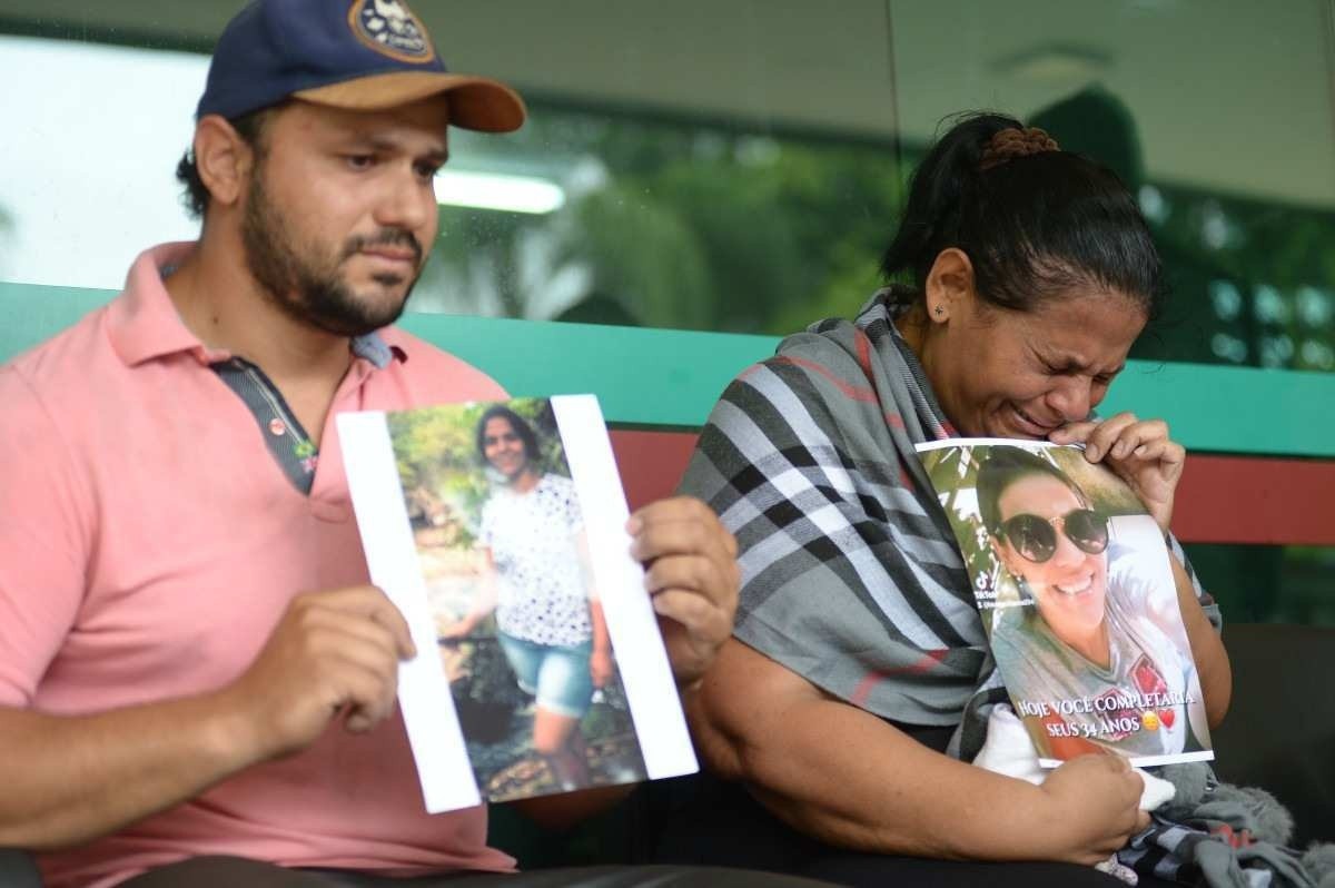 Bruno Guilherme (irmão de Jennifer Caroline Gomes) e Mãe de Caroline Gomes de Lima, 33, Juscilene Gomes, 54,  seguram foto da vítima na 14ª DP (Gama)