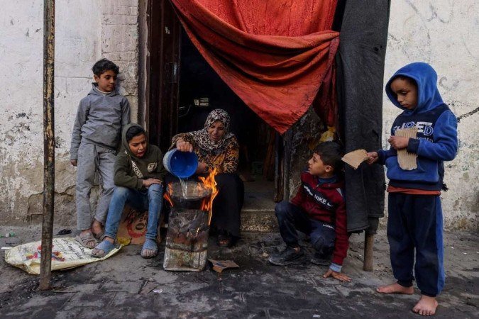 Palestina prepara refeição do lado de fora de sua casa, no sul da Faixa de Gaza - (crédito: Mohammed Abed/AFP) Palestina prepara refeição do lado de fora de sua casa, no sul da Faixa de Gaza - (crédito: Mohammed Abed/AFP)