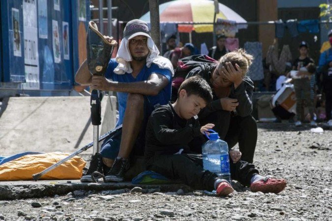 O migrante venezuelano Marcel Maldonado (L), seu filho Samuel (C) e sua esposa Andrea descansam no abrigo Paso Canoas em Puntarenas, Costa Rica, em 28 de setembro de 2023       -  (crédito:  Ezequiel Becerra / AFP)