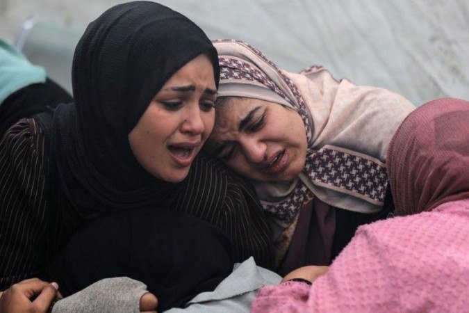 Mulheres no hospital de Al Aqsa velam entes queridos após bombardeio no domingo -  (crédito: NurPhoto via Getty)