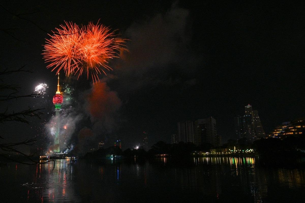 Fogos de artifício explodem ao lado da Torre Lótus durante as celebrações da véspera de Ano Novo em Colombo, em 1º de janeiro de 2024