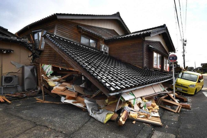 Carro preso sob uma casa desmoronada em Wajima, província de Ishikawa, um dia depois que um grande terremoto de magnitude 7,5 atingiu a região de Noto, na província de Ishikawa, à tarde.       -  (crédito: Kazuhiro NOGI / AFP)