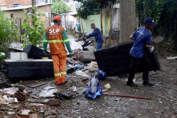 Na Vila Cauhy, funcionários do SLU limpam e recolhem objetos estragados pela chuva em janeiro deste ano -  (crédito:  Marcelo Ferreira/CB/D.A Press)