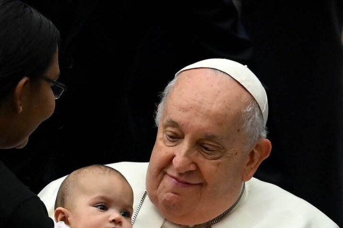 Francisco segura bebê durante a audiência geral, em 3 de janeiro:  -  (crédito: Filippo Monteforte/AFP)