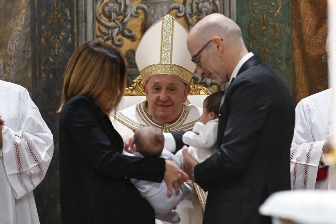 Esta foto tirada e divulgada em 7 de janeiro de 2024, pela mídia do Vaticano, mostra o Papa Francisco batizando crianças durante as celebrações da Festa do Batismo do Senhor, na Capela Sistina do Vaticano       -  (crédito: SIMONE RISOLUTI / VATICAN MEDIA / AFP)