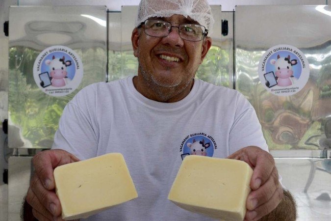 Rodrigo de Castro segurando queijo meia cura feito artesanalmente por ele

