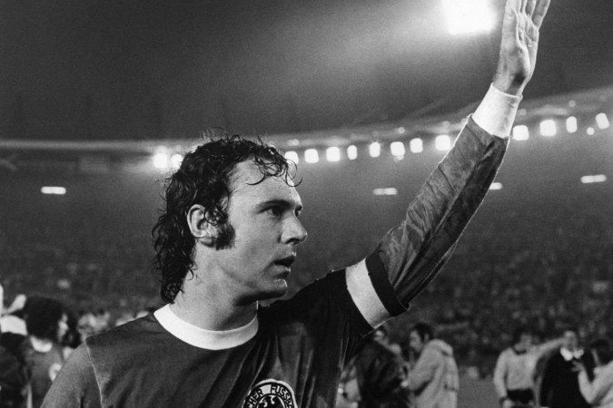 O jogador de futebol alemão Franz Beckenbauer acena para os espectadores após vencer a final da Copa do Mundo de 1974 contra a Suécia, em Dusseldorf, em 30 de junho de 1974       -  (crédito: JAN COLLSIOO / PRESSENS BILD / AFP)